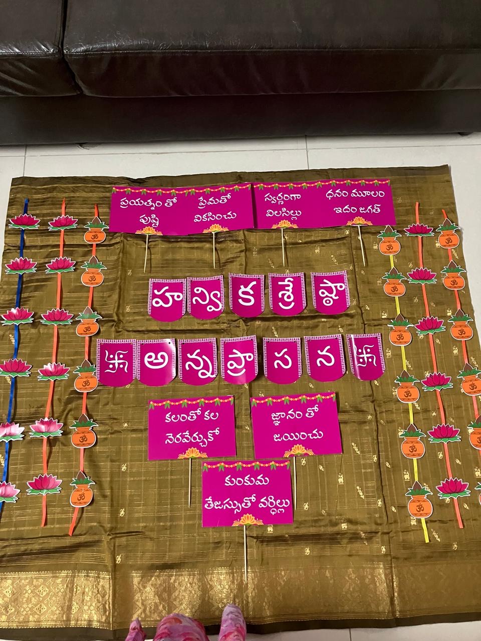 Annaprasana backdrop with pink Telugu letters pinned on a gold saree