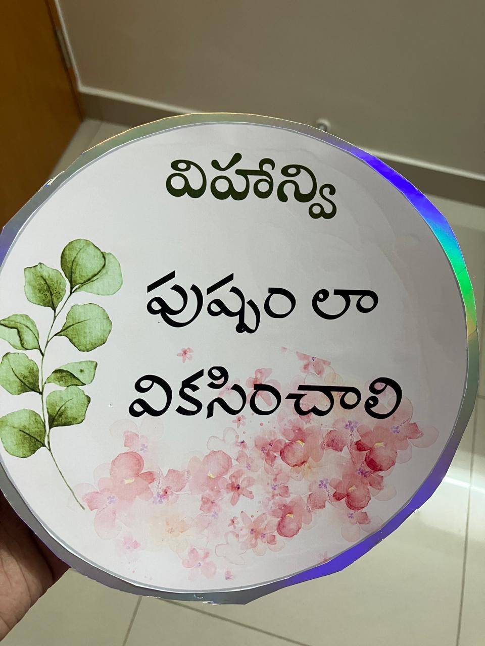 Round milestone blessing card with watercolour flowers and Telugu lettering