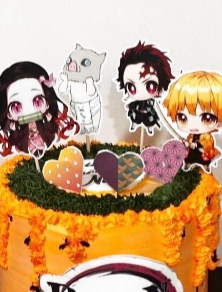 Demon Slayer character toppers on an orange birthday cake