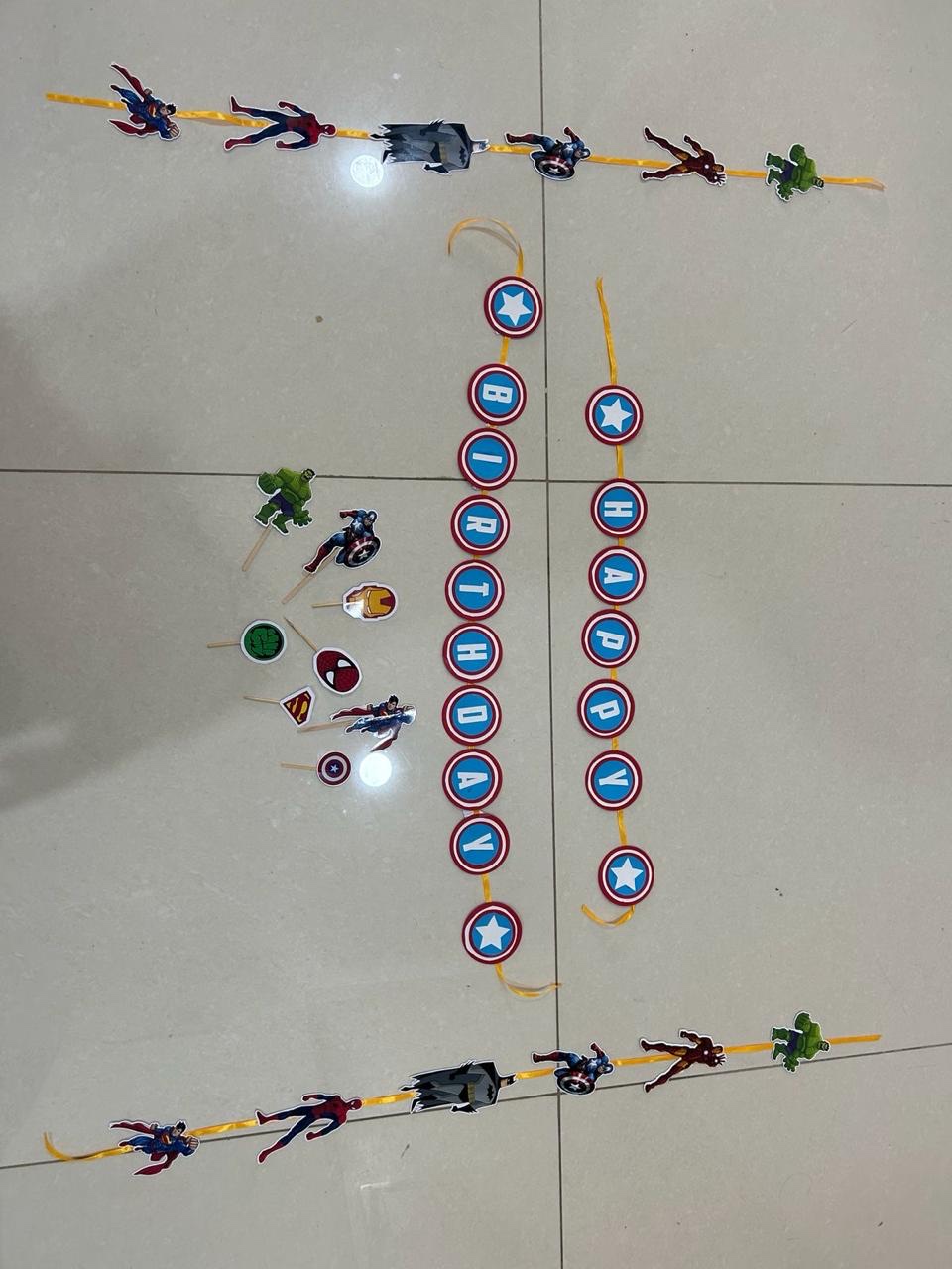 Avengers themed party backdrop with hanging character strips