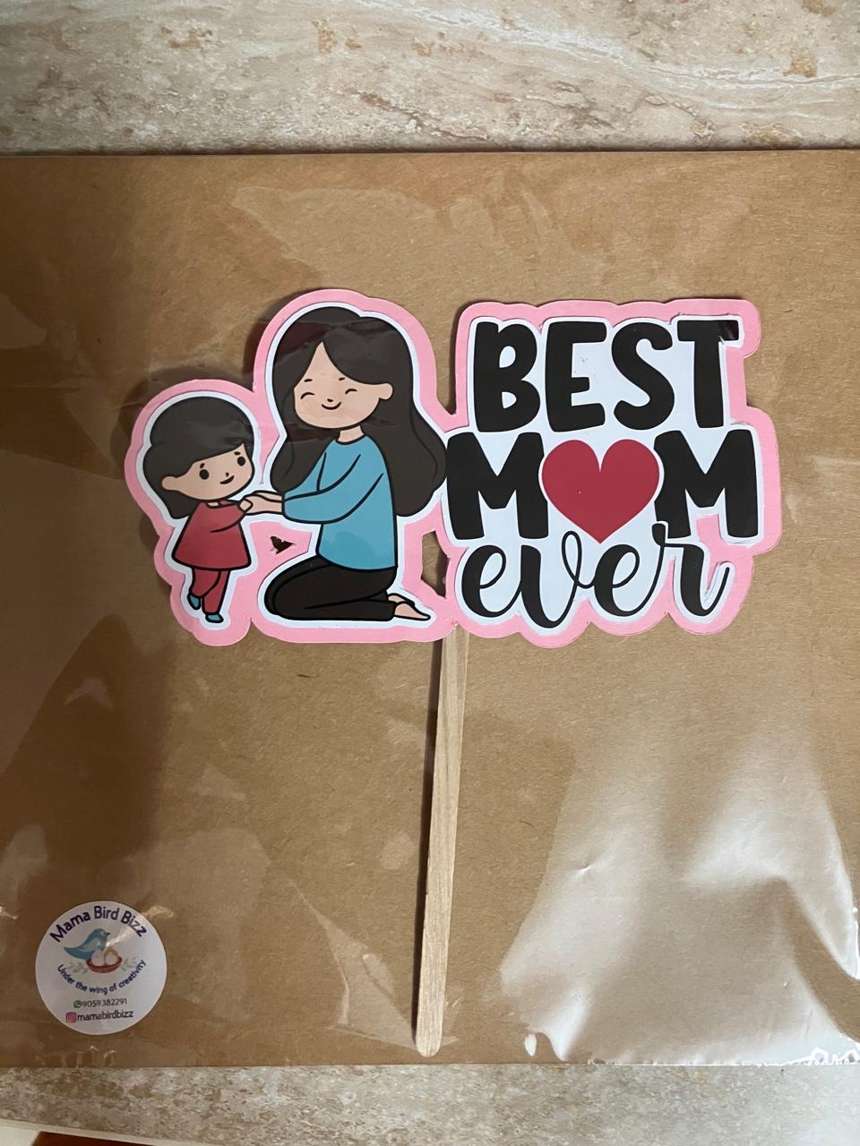 A Best Mom Ever topper packed in a box with the Mama Bird's Nest sticker